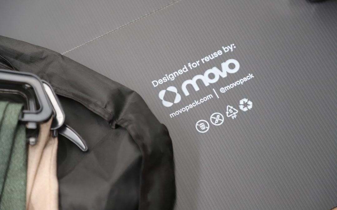 Clothing lying on a black flat pack box with MovoPack logo